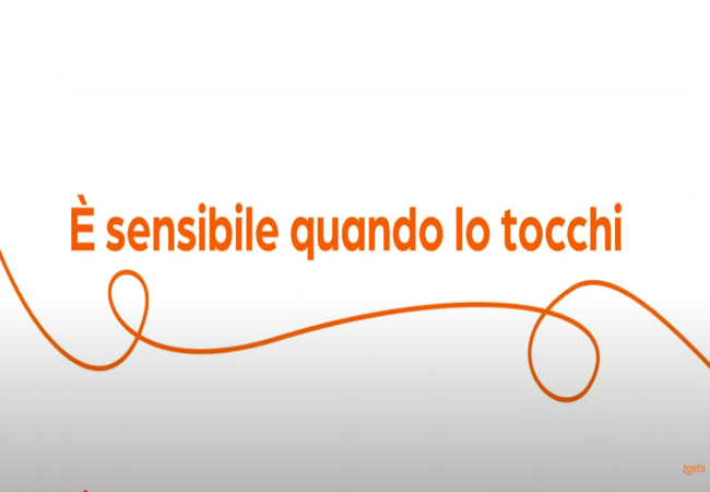 Testo "È sensibile quando lo tocchi" con vortice arancione su sfondo bianco.
